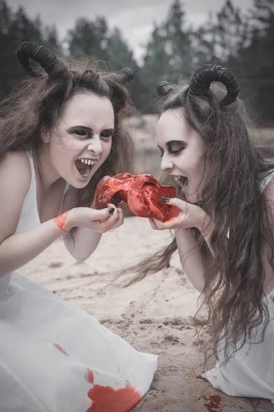 Two horrible demons eating raw meat — Stock Photo, Image