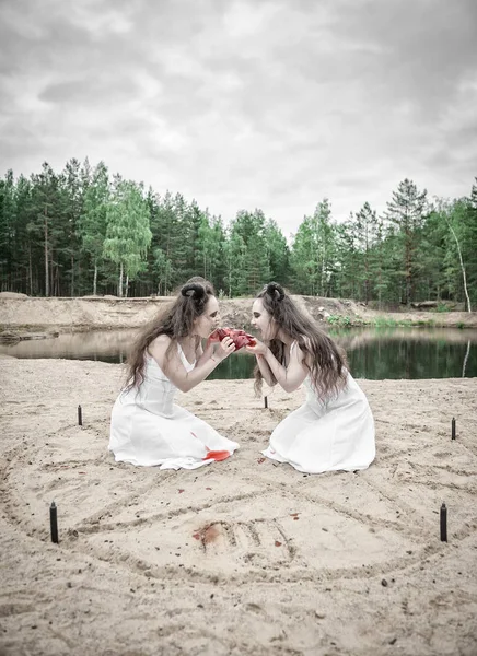 Två hemska demoner äter rått kött — Stockfoto