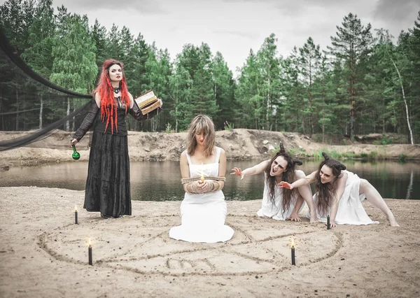 Mooie heks die hekserij maakt met gehoornde demonen en slachtoffer — Stockfoto