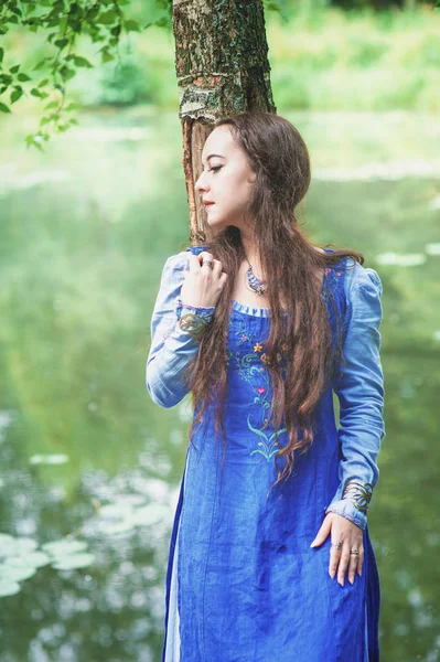 Beautiful woman in green medieval dress near river — Stock Photo, Image