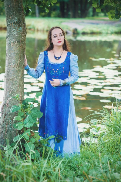 Vacker kvinna i grön medeltida klänning nära floden — Stockfoto