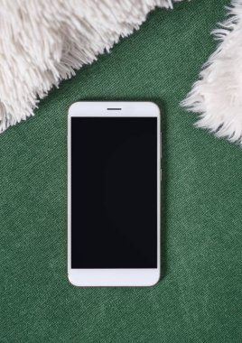 Kumaş arka planında boş akıllı telefonu olan üst görünüm. Tasarım için hazırlan 