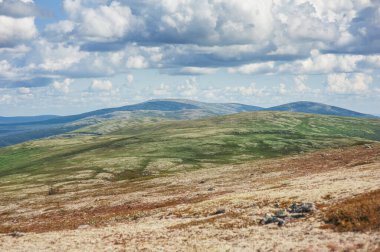 Tundra tepeleri ve gökyüzü bulutlarıyla güneşli güzel bir gün manzarası 