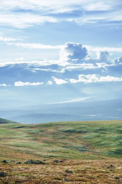 Tundra tepeleri ve gökyüzü bulutlarıyla güneşli güzel bir gün manzarası 