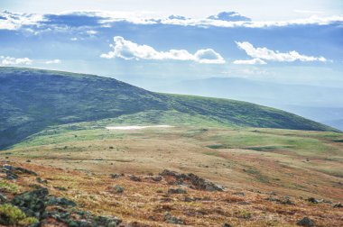 Tundra tepeleri ve gökyüzü bulutlarıyla güneşli güzel bir gün manzarası 