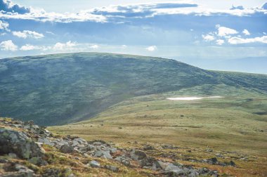 Tundra tepeleri ve gökyüzü bulutlarıyla güneşli güzel bir gün manzarası 