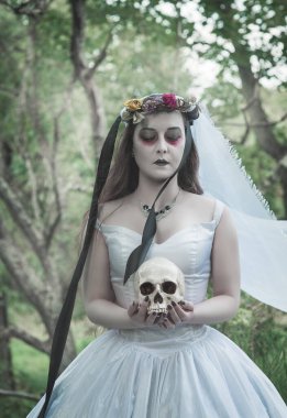 İnsan kafataslı, uzun elbiseli, ürkütücü ölü gelin. Cadılar Bayramı sahnesi 