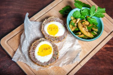 Haşlanmış yumurta, salatalık ve taze maydanozlu geleneksel İskoç et pirzolası.