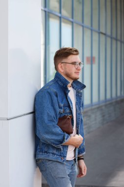iş adamı bir kot ceket ve bir çanta ile