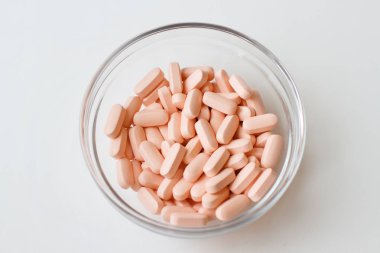 bir cam kabın içinde pembe tablet