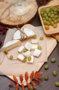 ahşap masa camembert peyniri ve yeşil üzüm