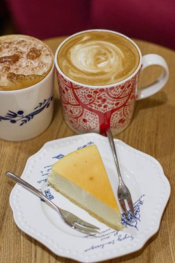 İki bardak kahve ve masanın üzerine cheesecake