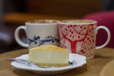 İki bardak kahve ve masanın üzerine cheesecake