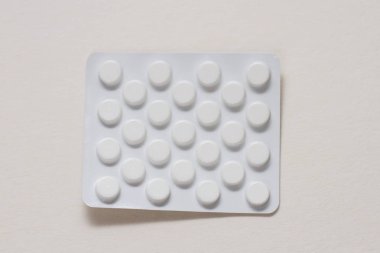 Beyaz zemin üzerinde bir blister hap