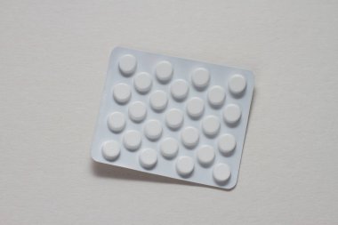 Beyaz zemin üzerinde bir blister hap