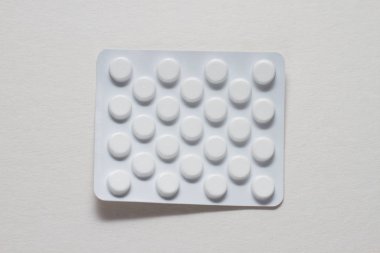 Beyaz zemin üzerinde bir blister hap