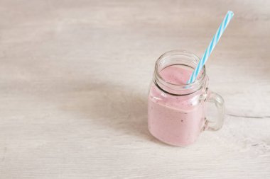 milkshake berry güler yüzlü bir cam kavanoz kupa bir saman ile. Uzay kopyalayın. RAW, vegan, vejetaryen, gıda kavramı.