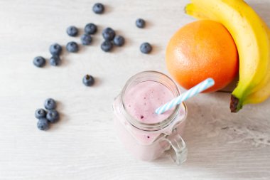 blueberrie güler yüzlü bir saman ve taze meyve ile bir kavanoz kupa