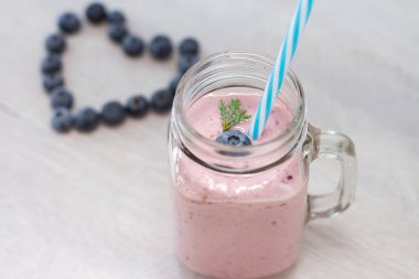 blueberrie şekli kalp ve güler yüzlü bir saman ile bir kavanoz kupa