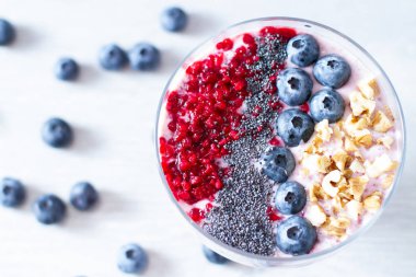 Sağlıklı kahvaltı kase: blueberry smoothie muz, ahududu, böğürtlen, tablo üzerinde fındık ile