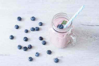 Sağlıklı kahvaltı kase: blueberry smoothie muz, ahududu, böğürtlen, tablo üzerinde fındık ile
