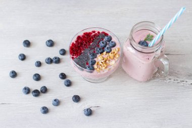 blueberrie güler yüzlü bir kavanoz kupa masada bir saman ile