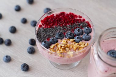 blueberrie güler yüzlü bir kavanoz kupa masada bir saman ile