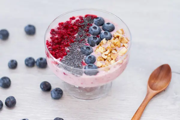 Sağlıklı kahvaltı kase: blueberry smoothie muz, ahududu, böğürtlen, tablo üzerinde fındık ile
