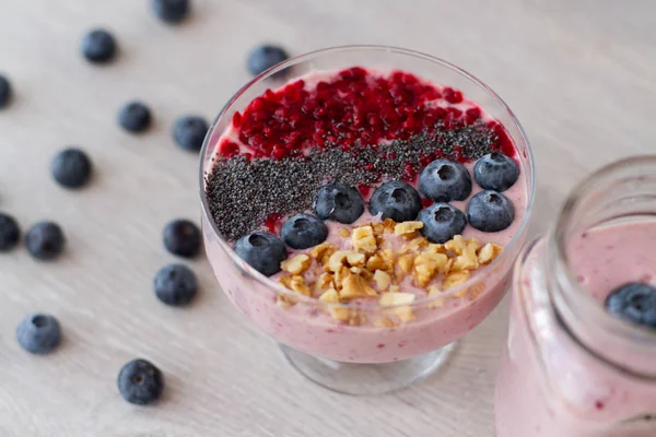 blueberrie güler yüzlü bir kavanoz kupa masada bir saman ile