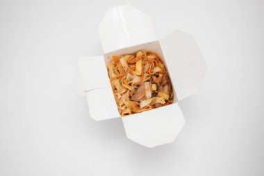 Kutuda Çin eriştesi. Paket servis. Tatlı ve ekşi soslu domuz eti.