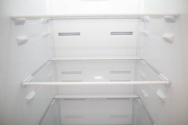 İçerideki Boş Buzdolabı 'na yakın çekim. Boş buzdolabı rafları.