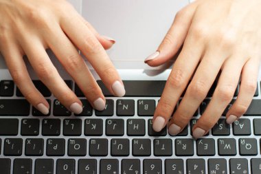 Dizüstü bilgisayarda yazı yazan kadınların üst görüntüsü. Dizüstü bilgisayarda çalışan bir programcının düz elleri.