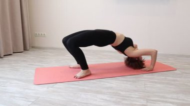 Glute Köprüsü egzersizi yapan genç bir kadın. Yoga yapan bir kadın.