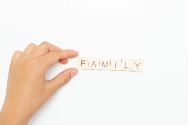 La mano de los niños sostiene la inscripción Familia —  Fotos de Stock