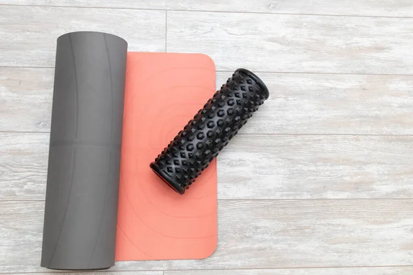 Foam roller and yoga mat in living room for meditation yoga. Top view.