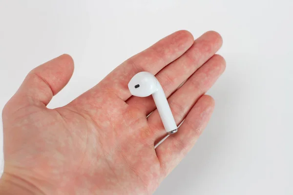 A person hand hold only one white Wireless headphones. Lost one earphone. — Stock Photo, Image