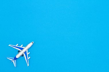 Mavi gökyüzü renk arka planında model uçak. Seyahat konsepti için düz dizayn.