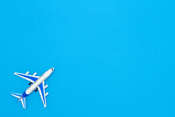 Model air plane on blue sky color background. Flat lay design for travel concept.