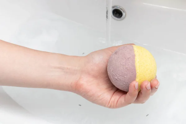 Hand made aromatic bath bombs on woman hand for SPA.