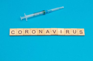 Kelime CORONAVIRUS mavi arka planda ahşap küplerden yapılmış