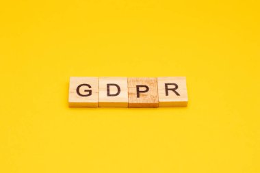 Genel Data Koruma Yönetmeliği. Sarı arkaplandaki tahta bloklardan yapılmış GDPR harfleri.