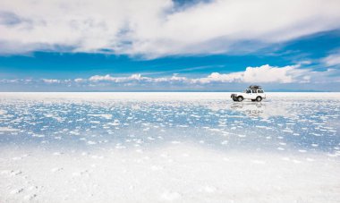 Salar de Uyuni, Bolivya - Mart, 26, 2017: Off-road araç Salar de Uyuni sürüş düz Bolivya'daki tuz