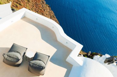 Deniz manzaralı terasta iki şezlong. Santorini Island, Yunanistan