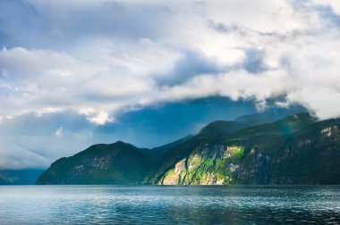 Norveç fiyordu üzerinde yağmurlu bulutlar ile Dağları. Yaz manzara