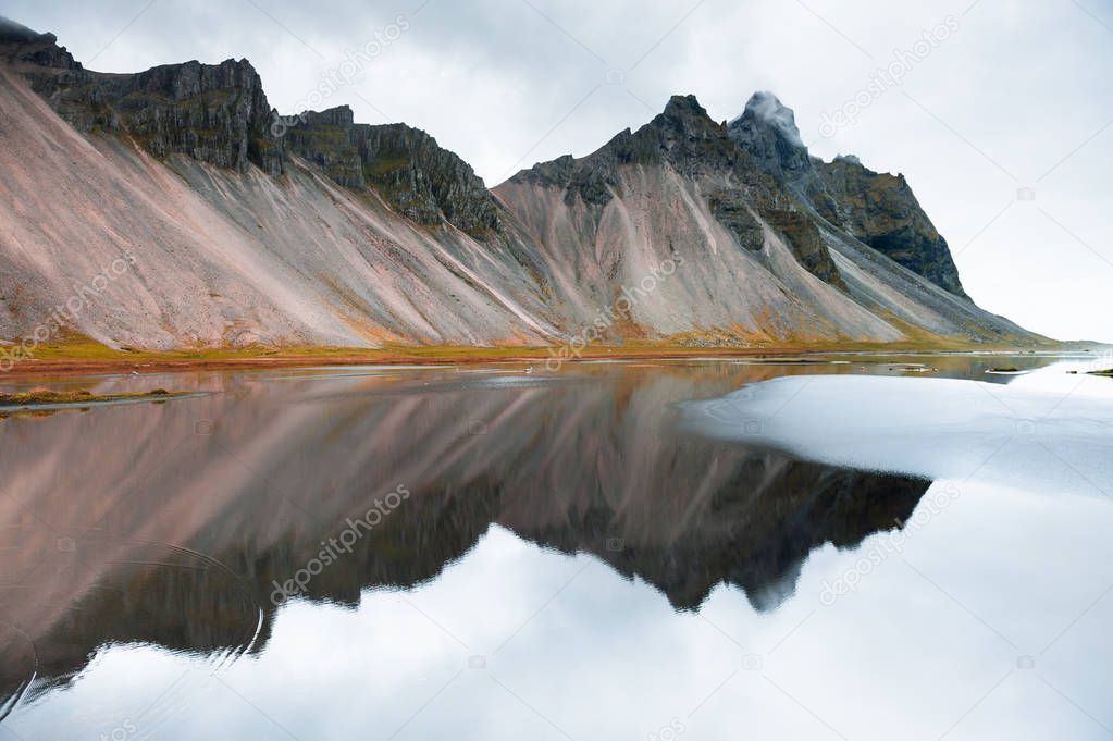 Mountains and reflections on the shore of Atlantic ocean, Iceland