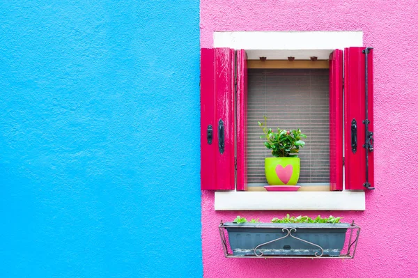 Окно с розовыми ставнями на сине-розовой стене . — стоковое фото