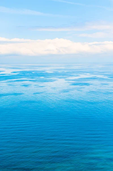 Blauwe zee en lucht met witte wolken. — Stockfoto