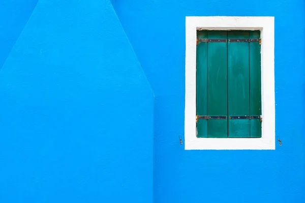 Fenêtre avec volets verts sur le mur bleu . — Photo