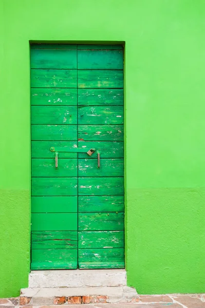 Green wooden door on the green wall.