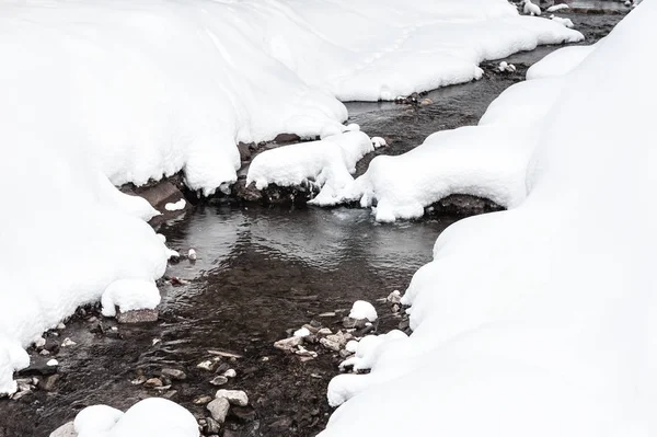 Arroyo en las montañas durante las nevadas . — Foto de Stock